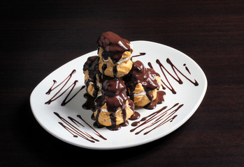 French profiterole with chocolate icing on a plate