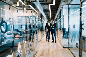 Obraz premium Multiracial businessmen having conversation in office corridor