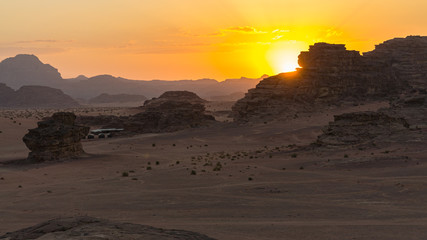Magic sunset in Mountains of Wadi Rum Desert, Jordan. Red-brown mountains in last rays of  setting sun. There is place for text.