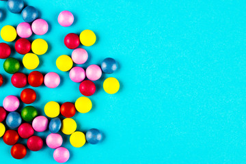 Jelly beans are scattered on a blue background.