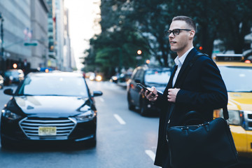 Young guy with phone crossing street