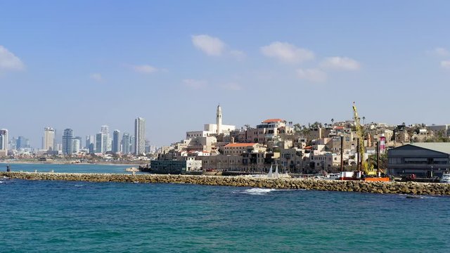 Aerial of Jaffa old city port to Tel Aviv coastline, including close pass and pan left by St. Peter church bell tower heading north to Tel Aviv.
