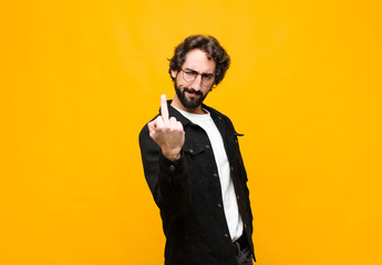 young crazy handsome man feeling angry, annoyed, rebellious and aggressive, flipping the middle...