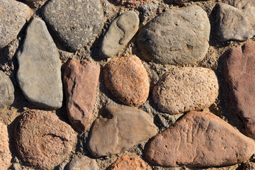 Background of colored stones. The surface is decorated with natural material. Pattern on the floor of multicolored pebbles.