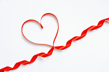 red satin ribbon in the form of a heart on a white background, the concept of Valentine's Day, a gift, a declaration of love