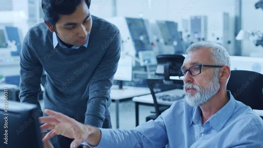 Poster modern factory office: asian project manager talks to caucasian senior engineer who's working on com