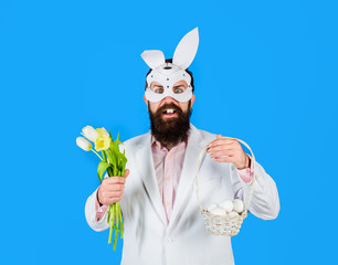 Happy bearded man with bunny ears hold basket with eggs. Man with bouquet tulips. Bunny man. Easter hunt. Bunny ears. Spring sale. Discount. Preparation for Easter. Easter Day. Happy easter. Holidays.