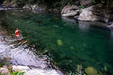 Woman in crystal clear water river in Colombia