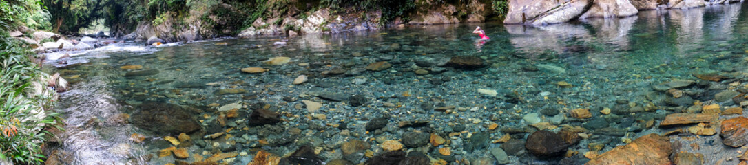 Fototapeta na wymiar Woman in crystal clear water river in Colombia