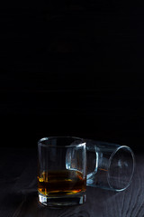 alcoholic drinks. glass of whiskey with ice on a black background. two glasses of whiskey on a wooden table.