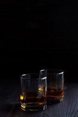 glass of whiskey and ice on wooden table