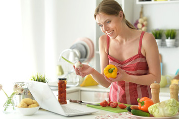 Portrait of beautiful young woman cooking in kitchen