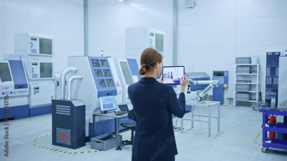 Poster Modern Factory: Female Engineer Uses Digital Tablet Computer with Augmented Reality Software to Visualize Workshop for Room Mapping, Floor Layout. Facility with High-Tech CNC Machinery and Robot Arm