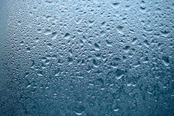 Close Up detail of moisture condensation problems, water drops, texture colorful water drop. Hot water vapor condensed on the cold window glass