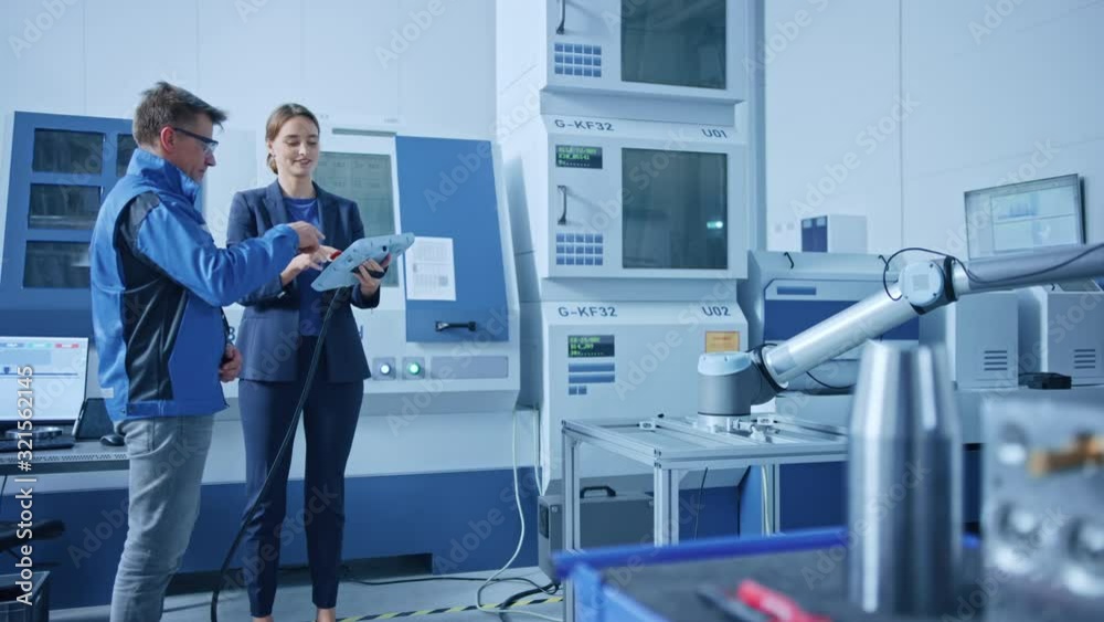 Poster modern factory: female project manager and male engineer standing, talking and using tablet computer