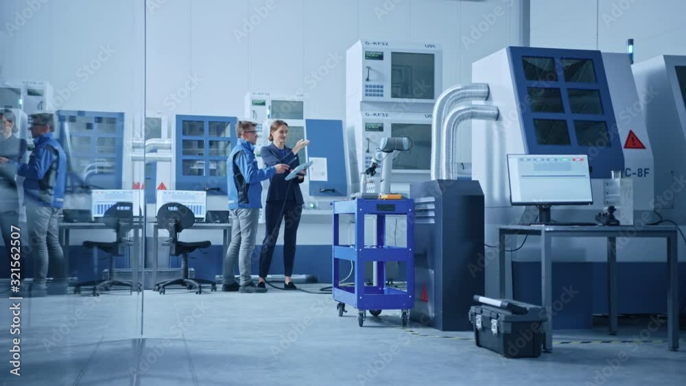 Poster modern factory: female project manager and male engineer standing, talking and using tablet computer