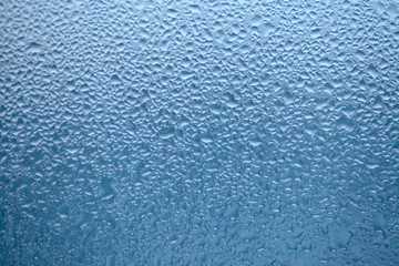 Drops of condensed steam, water drops. Close up detail of moisture condensation problems. Hot water vapor condensed on the cold window glass