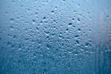 Drops of condensed steam, water drops. Close up detail of moisture condensation problems. Hot water vapor condensed on the cold window glass