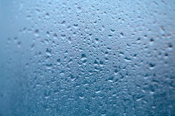 Drops of condensed steam, water drops. Close up detail of moisture condensation problems. Hot water vapor condensed on the cold window glass