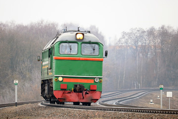 Obraz premium old diesel locomotive moving to a train station