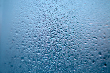 Drops of condensed steam, water drops. Close up detail of moisture condensation problems. Hot water vapor condensed on the cold window glass
