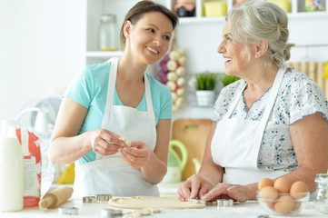 Obraz na płótnie Canvas Beautiful women baking in the kitchen at home