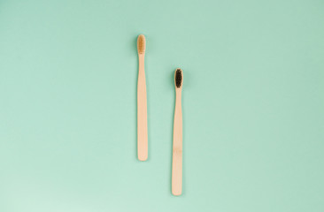 Two bamboo brushes for brushing teeth, light dark pile.