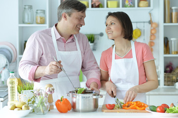Happy husband and wife cooking together in the kitchen