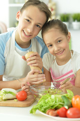 Cute brother and sister cooking together in kitchen