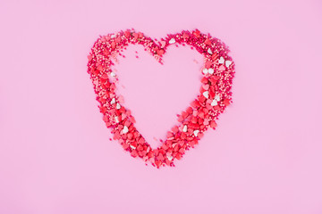 A big heart of little sweet hearts on a pink background.