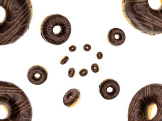Baked unhealthy round. Falling chocolate donuts isolated on white.