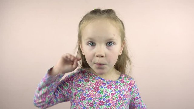 Happy little child girl looking at the camera and grimacing, 4k