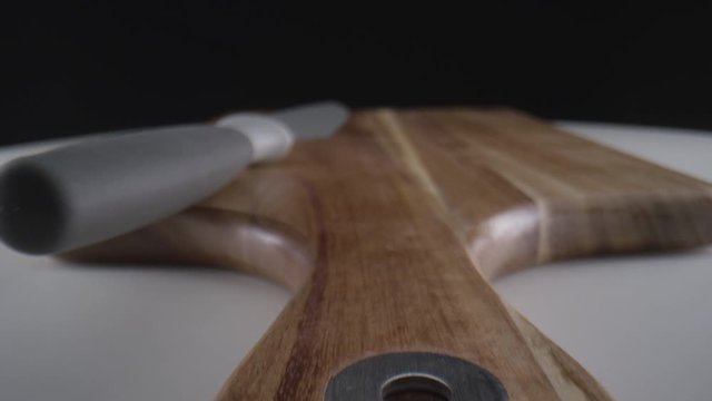 A knife and cutting board macro close up slider reveal cinematic chef's kitchen