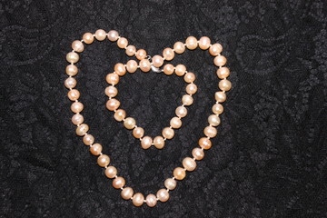 Heart made of pearls on a black background. Heart made of beads. Heart for valentines day.