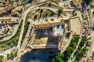 Fototapeta premium Aerial view of Atalaya castle over Villena Spain. The fortress has concentric plan, with a rectangular barbican forming space in front of the keep. The external wall has chemin-de-ronde or wall-walk