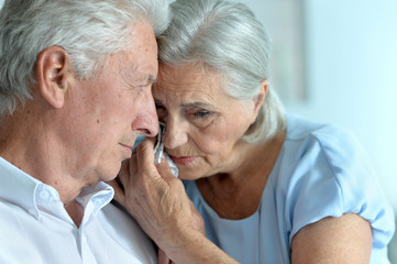 Portrait of sad senior couple posing at home