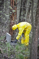 professional in protective coveralls preparing to taking sample  to container in  contaminated area