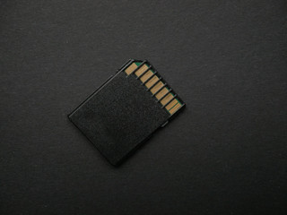 Mini SD memory card on black paper background close up