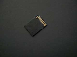 Mini SD memory card on black paper background close up