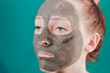 Girl in a clay mask. Cosmetology procedure