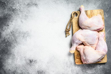 Raw chicken thighs on a chopping Board. Gray background. Top view. Copy space.