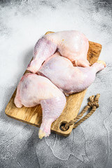 Raw chicken thighs on a chopping Board. Gray background. Top view