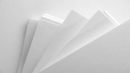 Several stacks of white paper on a white background