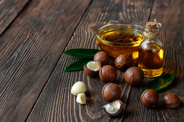 Obraz na płótnie Canvas Organic macadamia oil and macadamia nuts on a wooden background.