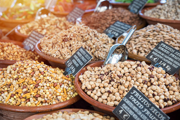 Table tray with a variety of nuts in a clay bowls. Trading outlet in the summer open-air market