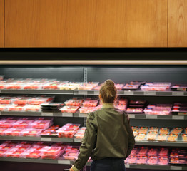 Woman purchasing a packet of meat at the supermarket	