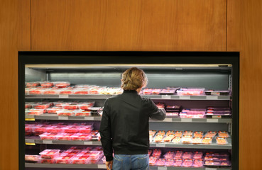 man purchasing a packet of meat at the supermarket	