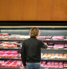 man purchasing a packet of meat at the supermarket	