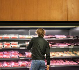 man purchasing a packet of meat at the supermarket	