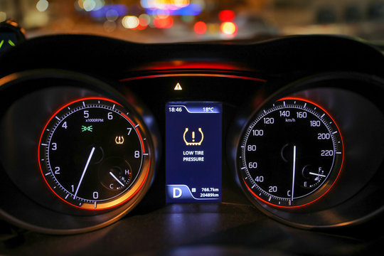 Low tire pressure error sign. Warning lights flash on the car dashboard. 